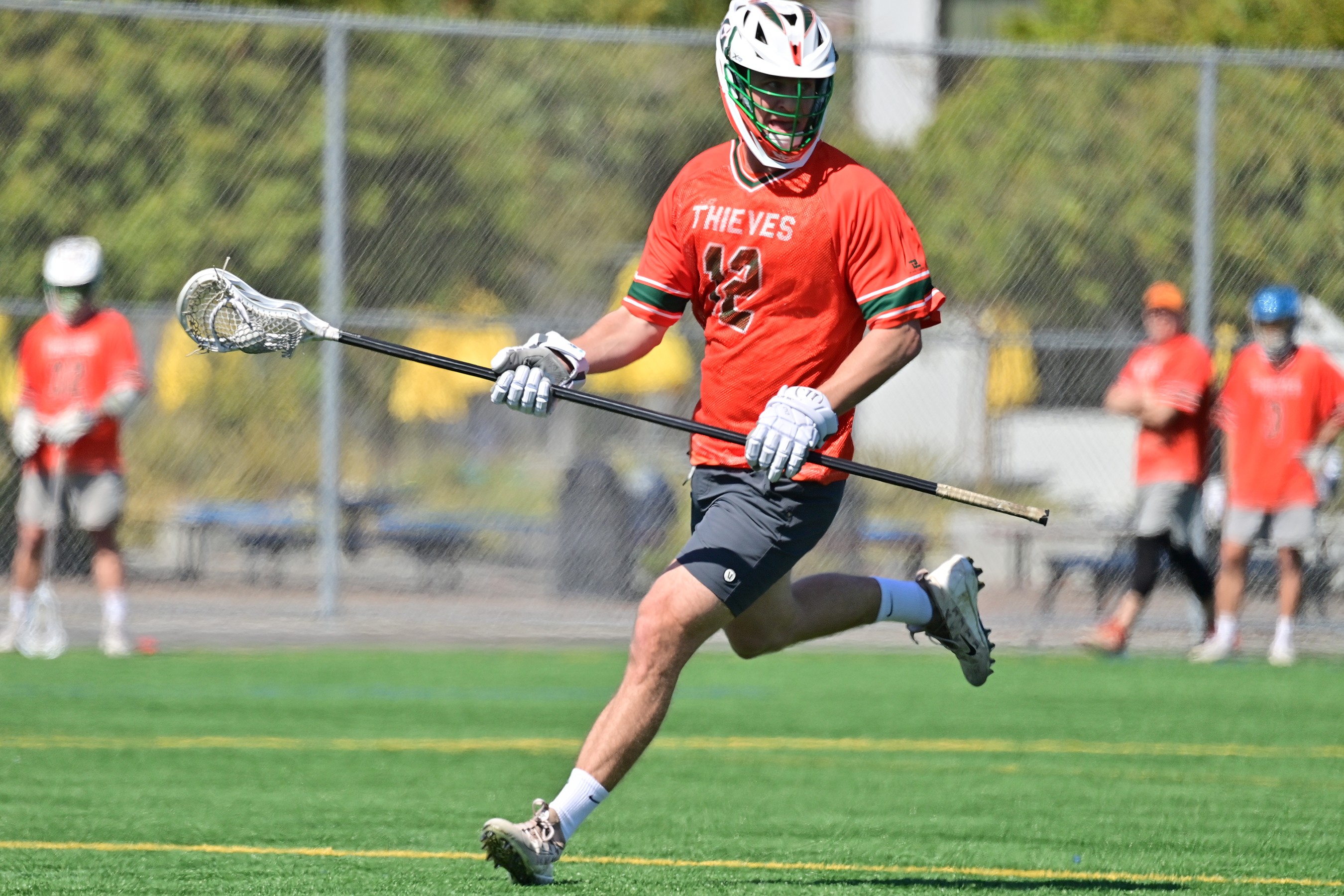 Club lacrosse player running upfield