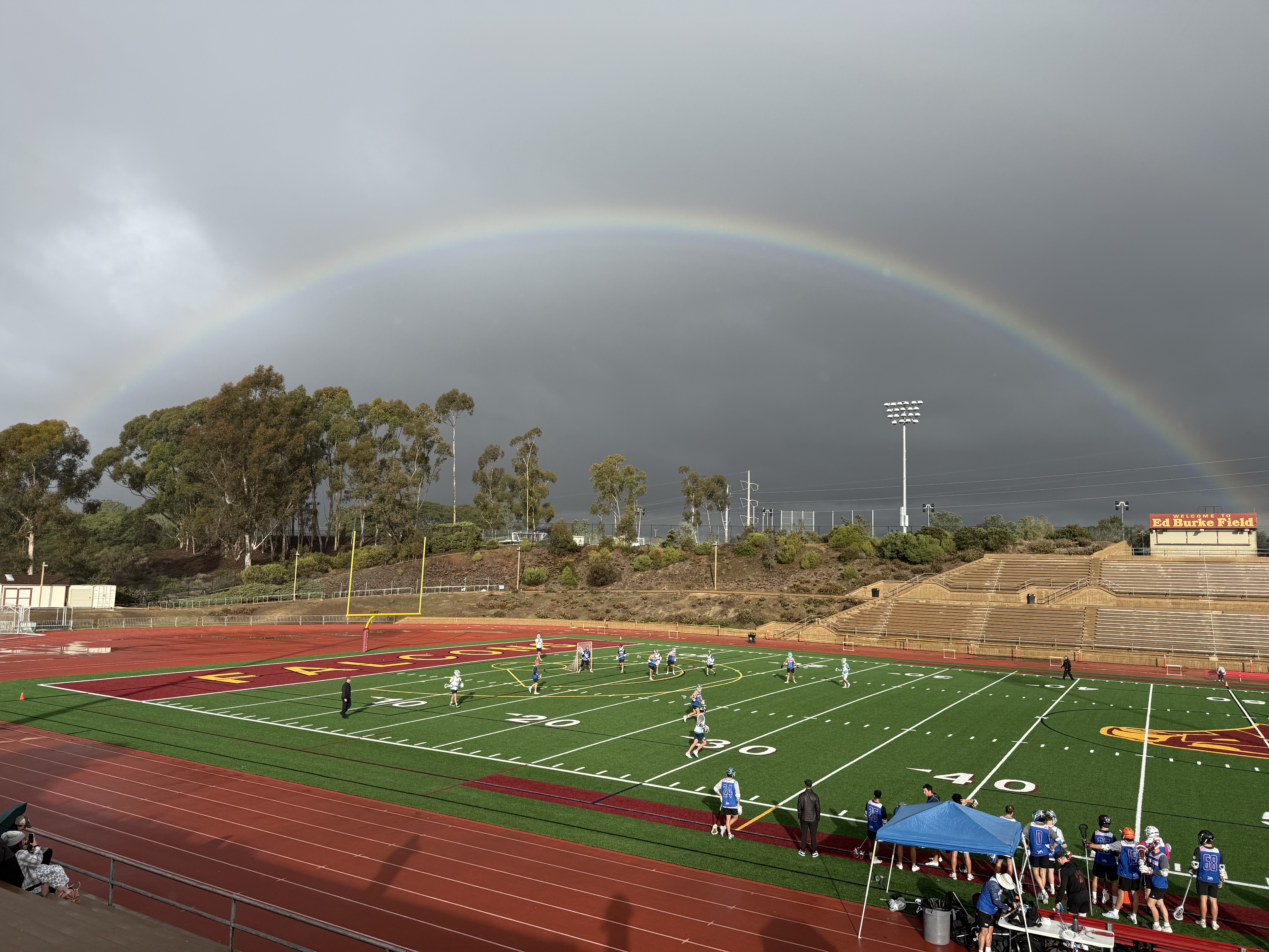 Club sports team on the field under a rainbow